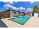 Backyard view showcasing an in-ground pool, privacy fence, and home exterior with dark trim and white stucco at 2716 Salt Lake St, North Las Vegas, NV 89030