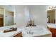 Bright bathroom features a soaking tub, tiled countertops, and a large mirror at 283 Auster Park Ave, Las Vegas, NV 89148