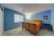 Cozy bedroom with carpet, a wooden bed frame, and a blue accent wall at 283 Auster Park Ave, Las Vegas, NV 89148