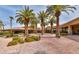 Beautifully landscaped community entrance featuring palm trees, brick pathways, and well-maintained buildings at 283 Auster Park Ave, Las Vegas, NV 89148