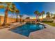 Beautiful pool and spa with a slide surrounded by palm trees and a manicured lawn at 283 Auster Park Ave, Las Vegas, NV 89148