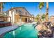 Backyard pool with rock waterfall feature and an outdoor kitchen at 284 Pointe Ranier Ave, Henderson, NV 89012