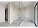 A glass shower with dual shower heads in a modern, tiled bathroom with natural light at 3430 Cosima Ln, Las Vegas, NV 89120