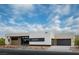 Contemporary one-story home with desert landscaping, a dark grey garage door and blue skies at 3430 Cosima Ln, Las Vegas, NV 89120
