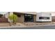 A one-story home with desert landscaping, a black trimmed glass front door, and grey driveway at 3430 Cosima Ln, Las Vegas, NV 89120