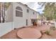 Expansive backyard with a cozy patio area perfect for relaxation and entertaining surrounded by trees and a fenced perimeter at 3491 Bankside Dr, Las Vegas, NV 89129