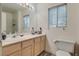 A bathroom with a sink vanity, window and toilet with wood look flooring at 3491 Bankside Dr, Las Vegas, NV 89129