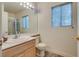 Bright bathroom with a large mirror, window, and light wood vanity at 3491 Bankside Dr, Las Vegas, NV 89129