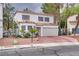 Charming home featuring a neutral stucco facade, red tile roof, meticulously maintained front yard, and an attached two-car garage at 3491 Bankside Dr, Las Vegas, NV 89129