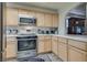 Well-lit kitchen with stainless steel microwave and oven and light wood cabinetry at 3491 Bankside Dr, Las Vegas, NV 89129