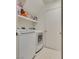 A laundry room with a washer, dryer, shelving and white geometric patterned floor at 3491 Bankside Dr, Las Vegas, NV 89129