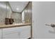 Well-lit bathroom features modern fixtures, beautiful wallpaper, and sleek countertop with storage at 360 E Desert Inn Rd # 604, Las Vegas, NV 89109