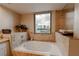 Relaxing bathroom with soaking tub, travertine tile, and views of the city skyline at 360 E Desert Inn Rd # 604, Las Vegas, NV 89109