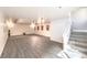 Spacious basement area with light gray wood floors and staircase to the main floor at 4045 Abernethy Forest Pl, Las Vegas, NV 89141