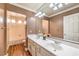 Well-lit bathroom featuring a double sink vanity, wood floors and a shower over tub at 4045 Abernethy Forest Pl, Las Vegas, NV 89141