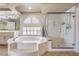 Spa-like bathroom with a large tub and a glass-enclosed shower at 4045 Abernethy Forest Pl, Las Vegas, NV 89141