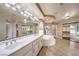 Luxurious bathroom with double sinks, a soaking tub, and a glass shower at 4045 Abernethy Forest Pl, Las Vegas, NV 89141