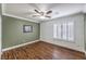 Comfortable bedroom featuring wood floors, shuttered windows, and ceiling fan at 4045 Abernethy Forest Pl, Las Vegas, NV 89141
