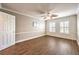 Cozy bedroom with wood floors, bright windows with shutters, and a classic ceiling fan at 4045 Abernethy Forest Pl, Las Vegas, NV 89141