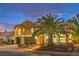 Beautiful two-story home with desert landscaping and lush palm trees lining the front walkway and entryway at 4045 Abernethy Forest Pl, Las Vegas, NV 89141