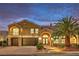 Beautiful two-story home with desert landscaping, driveway, three-car garage, and an inviting arched entryway at 4045 Abernethy Forest Pl, Las Vegas, NV 89141