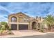 Beautiful two-story home with desert landscaping, driveway, three-car garage, and an inviting arched entryway at 4045 Abernethy Forest Pl, Las Vegas, NV 89141
