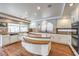 Bright kitchen featuring wood floors, custom island, white cabinetry and stainless steel appliances at 4045 Abernethy Forest Pl, Las Vegas, NV 89141