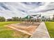 Community playground with swings, slides, and climbing structures, surrounded by green grass and a paved walkway at 4045 Abernethy Forest Pl, Las Vegas, NV 89141