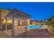 Beautifully designed backyard features a custom pool, spa, covered pergola, and outdoor kitchen at 4045 Abernethy Forest Pl, Las Vegas, NV 89141
