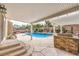 Inviting backyard pool and spa with covered patio and outdoor kitchen perfect for entertaining at 4045 Abernethy Forest Pl, Las Vegas, NV 89141