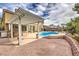 Backyard pool featuring a pergola covered outdoor kitchen area and brick paved patio at 4045 Abernethy Forest Pl, Las Vegas, NV 89141