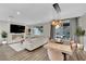 Open concept living space with a dining area that has a modern chandelier and a living area with a fireplace and TV at 409 Wind Poppy St, Las Vegas, NV 89138