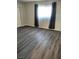 Bedroom with wood-look flooring, window with curtains, and a door at 4368 Vornsand Dr, Las Vegas, NV 89115