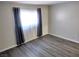 Bedroom featuring wood-look flooring and a window with blue and gray curtains at 4368 Vornsand Dr, Las Vegas, NV 89115