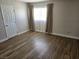 Bedroom with wood-look flooring, window with curtains, and a door at 4368 Vornsand Dr, Las Vegas, NV 89115