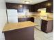 An open kitchen featuring wood cabinets, white appliances, and tile flooring at 4368 Vornsand Dr, Las Vegas, NV 89115