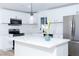 Close-up of a contemporary kitchen featuring white cabinets, quartz countertops, and stainless appliances at 4818 E Monroe Ave, Las Vegas, NV 89110
