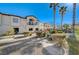 Exterior shot of a condo complex showcasing lush landscaping, a swimming pool, and towering palm trees at 4821 Black Bear Rd # 101, Las Vegas, NV 89149