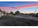 Sprawling backyard with pool, putting green, and ample space under a colorful sky at 616 Lacy Ln, Las Vegas, NV 89107
