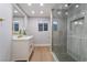 Modern bathroom with glass shower, white vanity, gold fixtures and wood-look floors at 616 Lacy Ln, Las Vegas, NV 89107