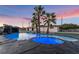This backyard features a pool and spa with palm trees and a waterfall at 616 Lacy Ln, Las Vegas, NV 89107