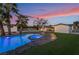 Backyard with a large pool, palm trees, and an artificial turf lawn at 616 Lacy Ln, Las Vegas, NV 89107