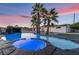 This backyard features a pool and spa with rock waterfall and palm trees at 616 Lacy Ln, Las Vegas, NV 89107