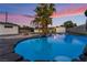 This backyard features a pool with rock waterfall and palm trees at 616 Lacy Ln, Las Vegas, NV 89107