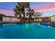 This backyard features a pool with rock waterfall and palm trees at 616 Lacy Ln, Las Vegas, NV 89107