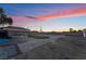 Backyard putting green and partially-viewed pool area under a vivid sunset at 616 Lacy Ln, Las Vegas, NV 89107