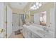 Well-lit bathroom with a single sink vanity, tiled floors, and a shower-tub combination at 6710 Pyracantha Glen Ct, Las Vegas, NV 89131