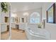 Luxury main bathroom featuring a soaking tub, dual vanities, and natural light at 6710 Pyracantha Glen Ct, Las Vegas, NV 89131