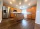 Bright kitchen features stainless steel refrigerator and wood grain cabinets and island at 7017 Green Ripple Ln, Las Vegas, NV 89156