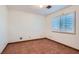 Bedroom featuring terracotta flooring, neutral walls, and a single window with white shutters at 798 Shirley Ln, Boulder City, NV 89005